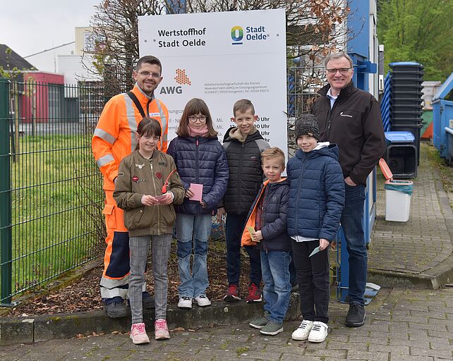 Zwei Mitarbeiter des Recyclinghof Oelde verteilen Eisgutscheine an Kinder um den Geburtstag des Recyclinghof zu feiern.