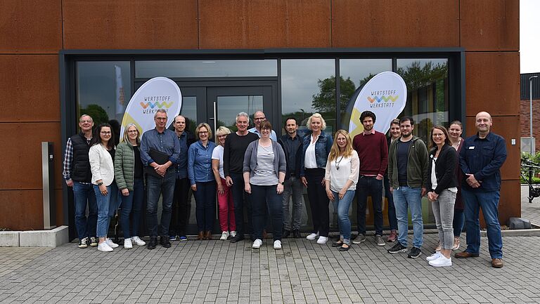 Gruppenfoto von Vertreterinnen und Vertretern der Abfallwirtschaft aus Westfalen vor der Wertstoffwerkstatt während des Austausches zur Öffentlichkeitsarbeit im Bereich Bioabfall
