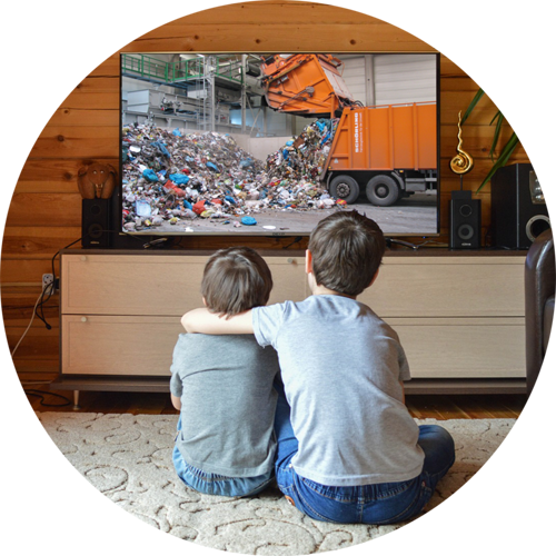 Zwei Kinder sehen sich einen Beitrag mit Müllauto im Fernseher an
